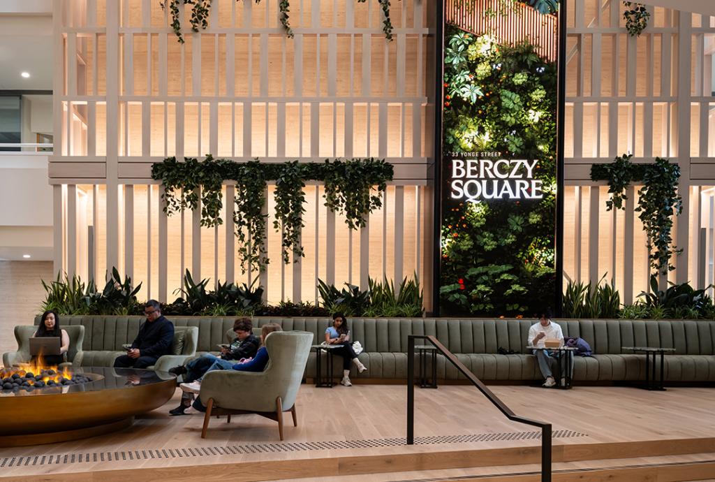 A photo of the Berczy Square lobby, with different types of seating and beautiful screen.